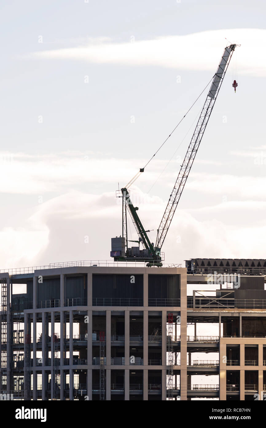 Una grúa se ve en la parte superior de un edificio en construcción en la capital de Gales, Cardiff en Cardiff, Gales, Reino Unido. Foto de stock