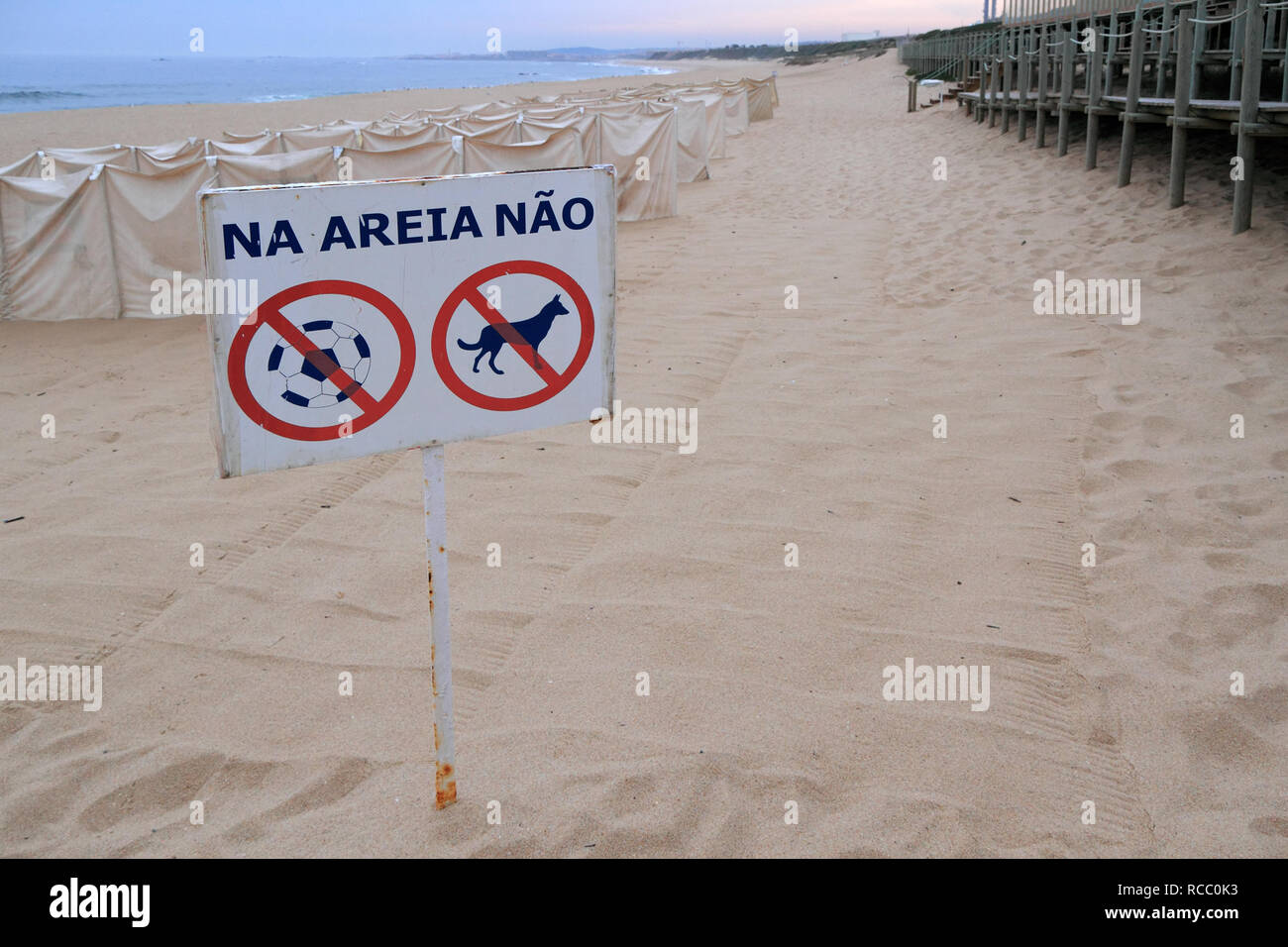 Advertencia de playa sighn en portugués que dice: 'no' en la arena (prohibido perros y partidos de fútbol) Foto de stock