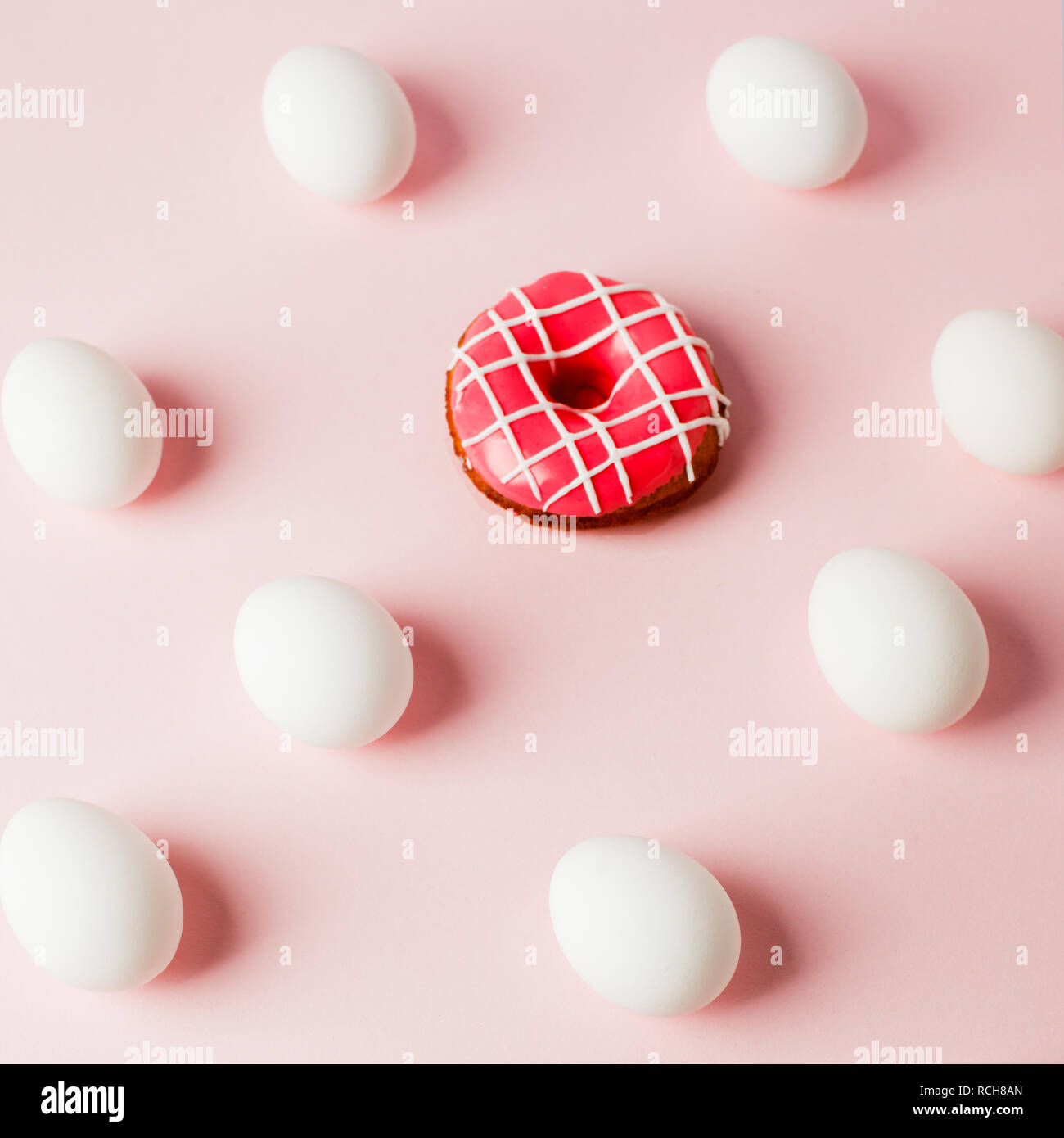 Huevos de Pascua con sombra y repetición donut rosa sobre fondo rosado pastel, error de sistema, copia el espacio, fondo de moda Foto de stock