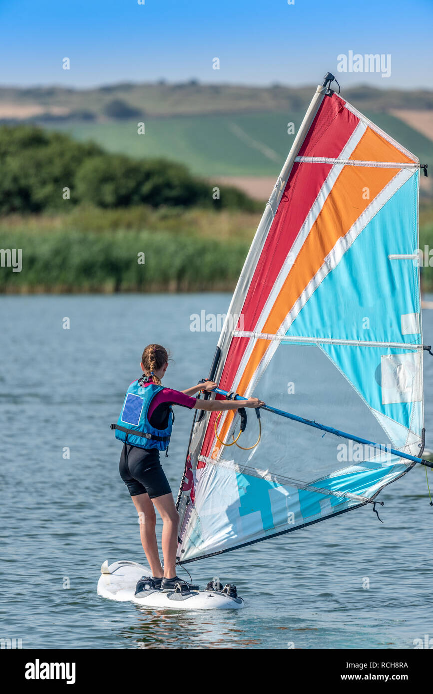 Niña aprender a hacer windsurf en el lago Fotografía de stock - Alamy