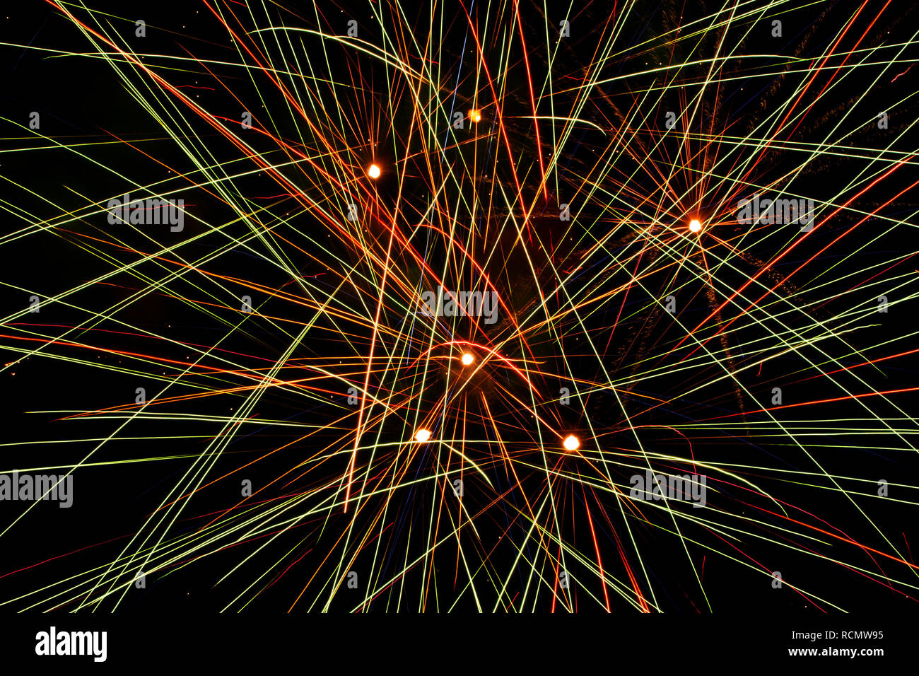 Primer plano de una explosión de fuegos artificiales en el cielo, haciendo líneas colorido abstracto a través de la oscuridad Foto de stock