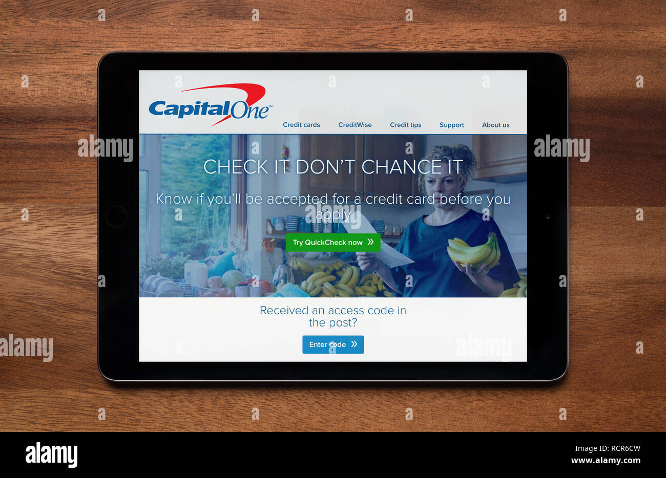 El sitio web de Capital One se ha visto en un iPad, que descansa sobre una mesa de madera (uso Editorial solamente). Foto de stock