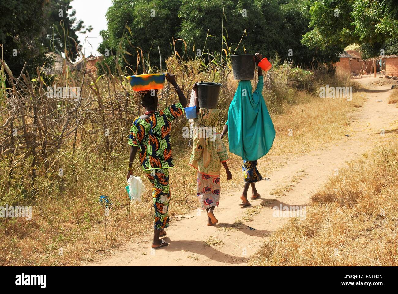 Tres niñas en Níger, África, volver desde el pozo de la aldea llevando  cubetas de agua sobre sus cabezas Fotografía de stock - Alamy