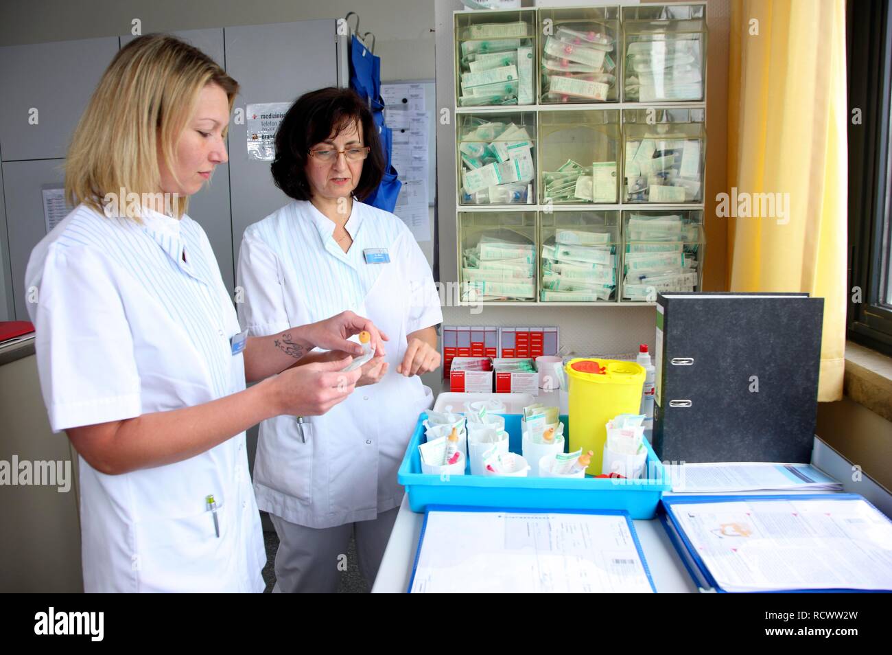 Las enfermeras de la preparación de los documentos y la medicina para los pacientes en la estación de enfermería de un hospital Foto de stock