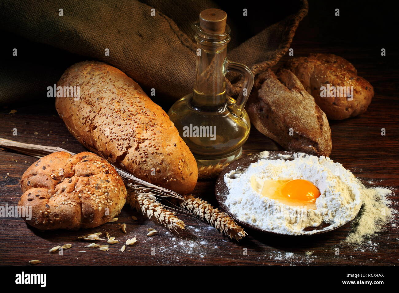 Bodegón con pan casero, espigas de trigo, mantequilla, huevos y harina  sobre una mesa de madera Fotografía de stock - Alamy