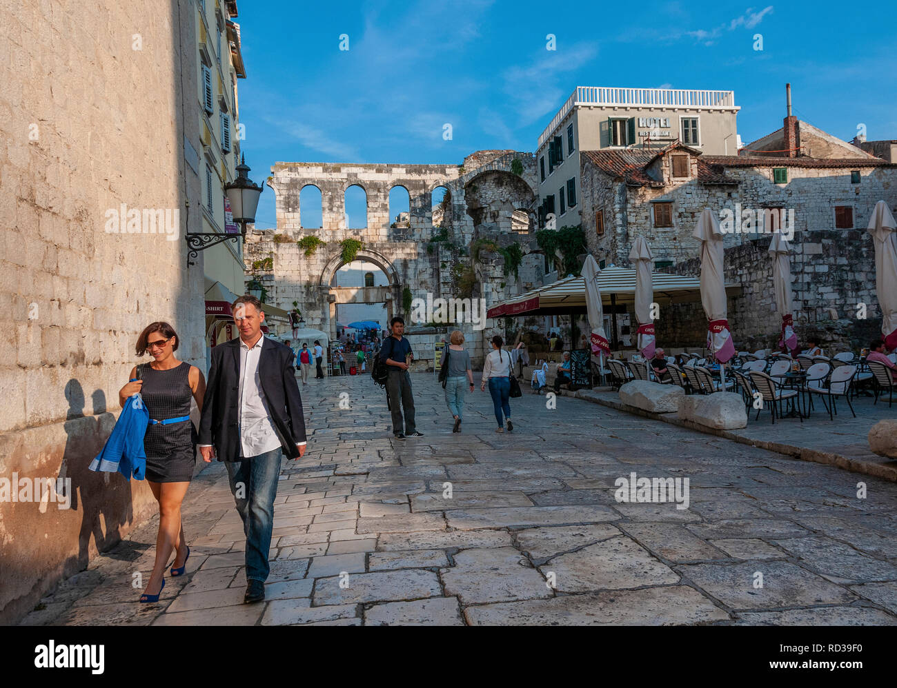Hay turistas que caminan a lo largo de un viejo camino pavimentado en la antigua ciudad romana de Split, en la costa Dálmata, Croacia Foto de stock