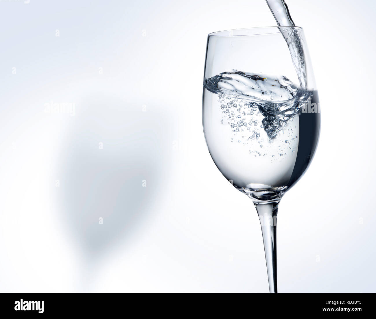 Imagen monocroma de verter agua en un vaso de vino, espacio para copiar Foto de stock
