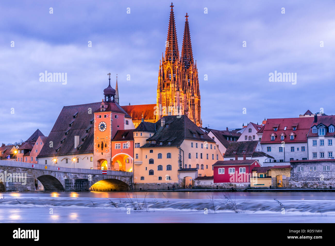 Regensburg, Alemania, el histórico Puente de Piedra, el Puente de la torre y edificios en la noche. Foto de stock