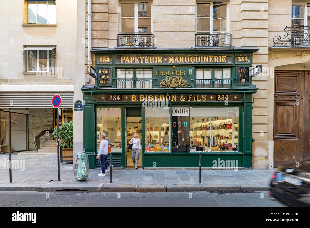 Un walking caminar fuera de la puerta de B. Biberon & Fils un minorista de artículos de cuero de lujo y artículos de papelería, París, Francia Foto de stock