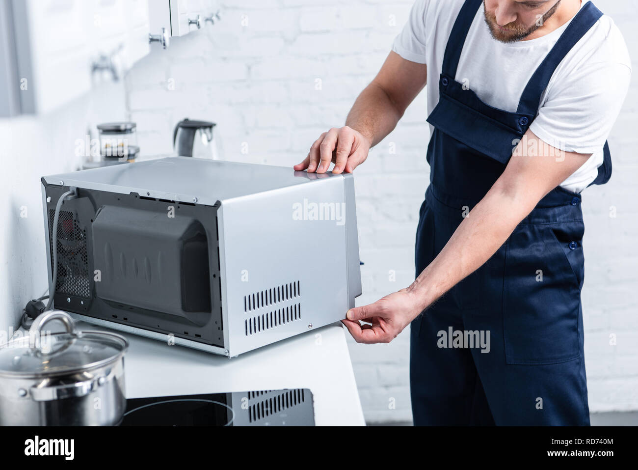 Vista parcial del adulto manitas reparación de microondas en la cocina  Fotografía de stock - Alamy