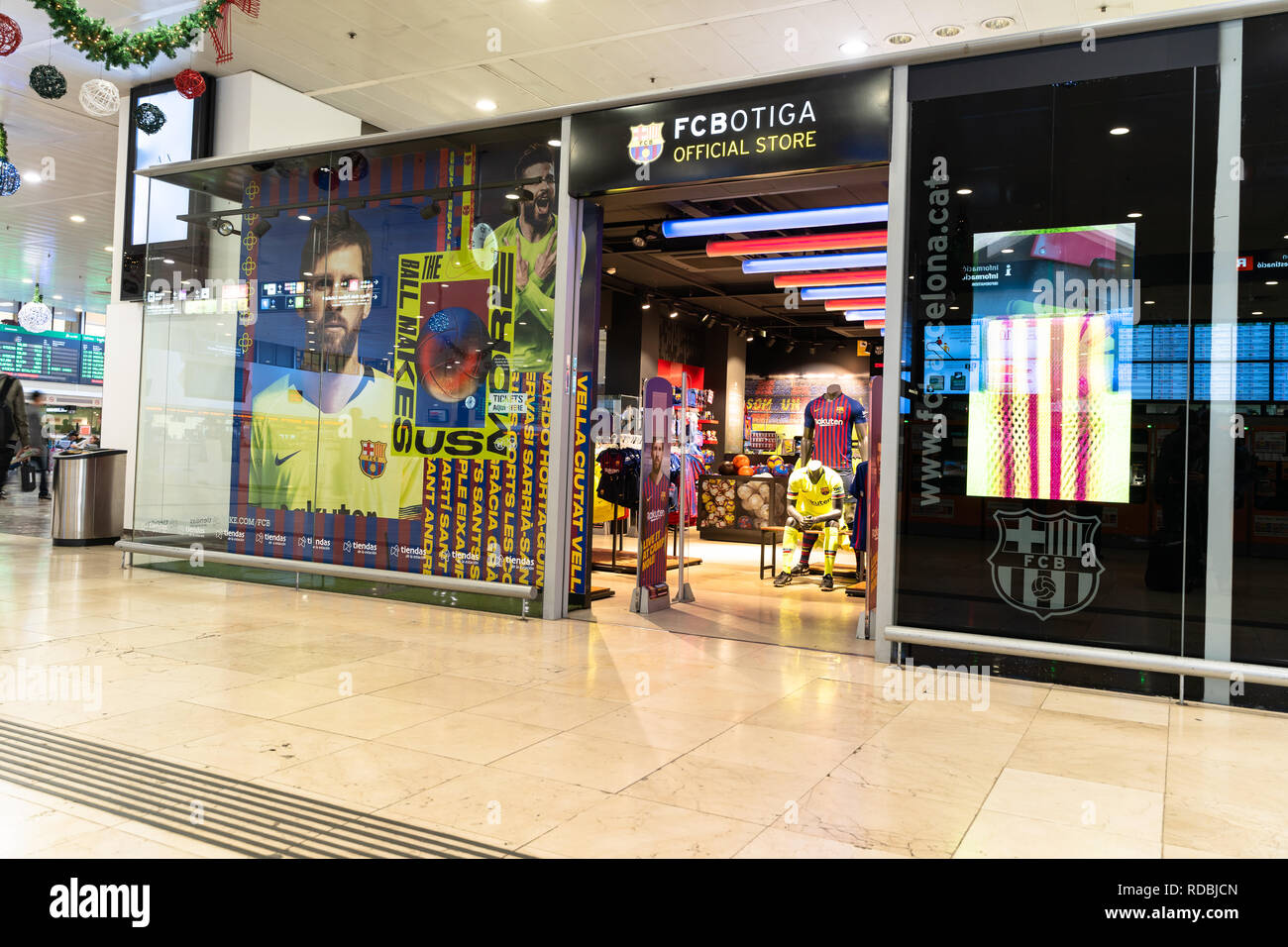 Entrada, fachada a la fc botiga tienda del equipo de fútbol del FC  Barcelona con un cartel por Lionel Messi en el escaparate. El FC Barcelona,  ​​Spain logotipo Fotografía de stock -