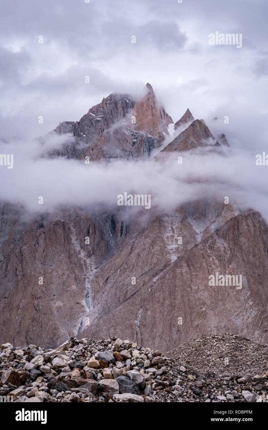 El majestuoso Pico de hermosas Torres Trango rodeado por nubes blancas en cordillera Karakoram en Pakistán. Foto de stock