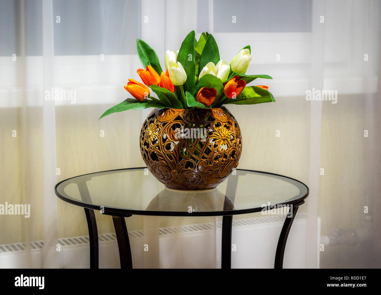 Un ramo de flores decorativas en un florero sobre una mesa de vidrio  Fotografía de stock - Alamy