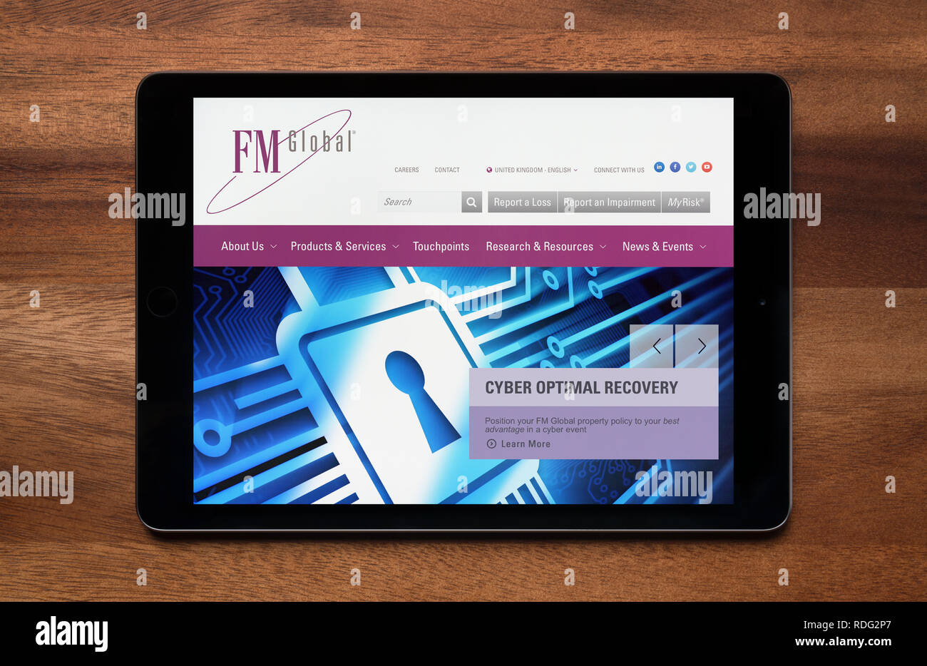 El sitio web de FM Global es visto en un iPad, que descansa sobre una mesa de madera (uso Editorial solamente). Foto de stock