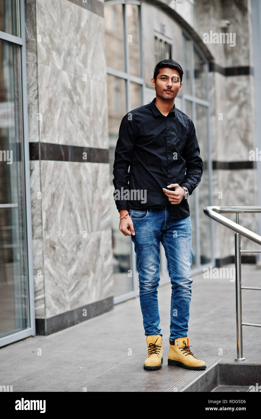 Soleado cable Restaurar Elegante modelo indio, hombre en ropa casual, camisa negra plantea en la  calle exterior de la India Fotografía de stock - Alamy