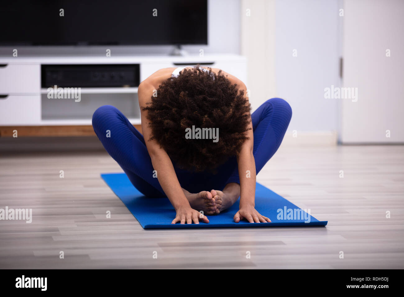 Mujer joven, meditar, sentado, en, alfombra, y, hacer, splits