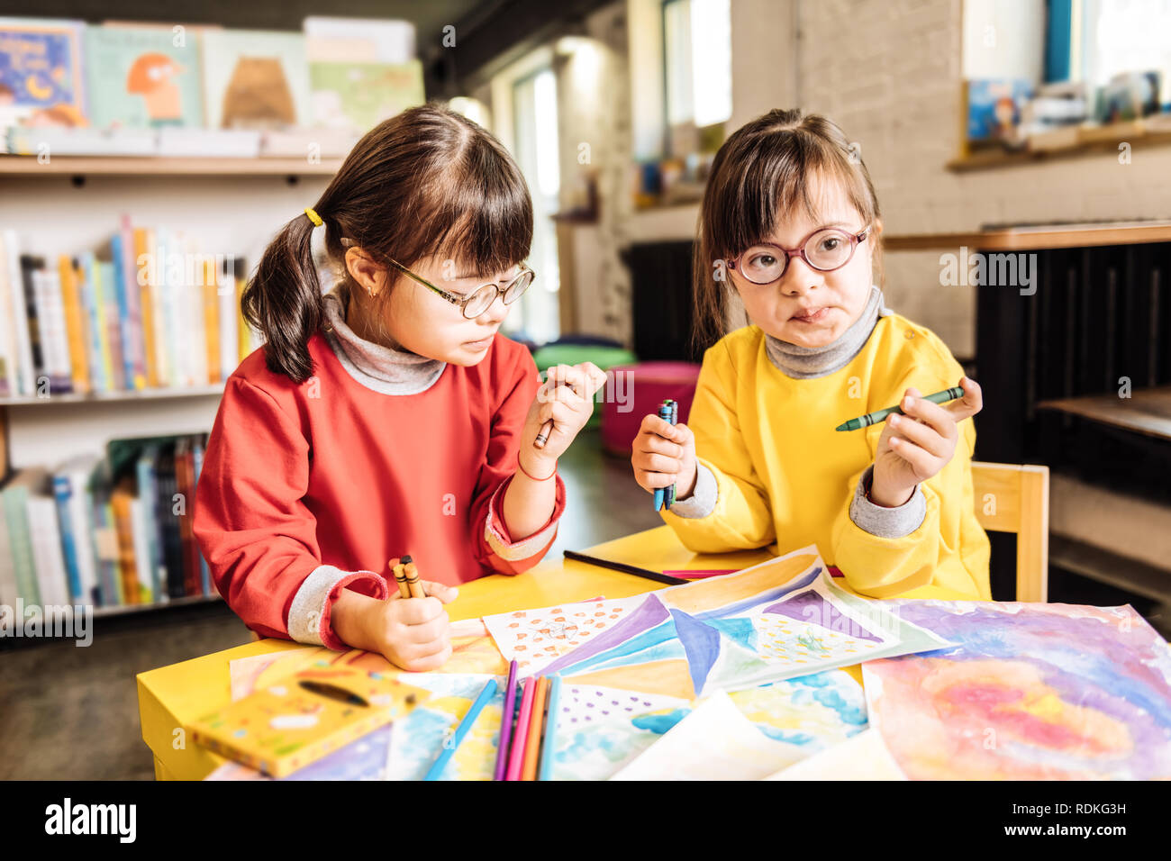 Dos niñas preescolares jugando y colorear imágenes en centro de rehabilitación Foto de stock