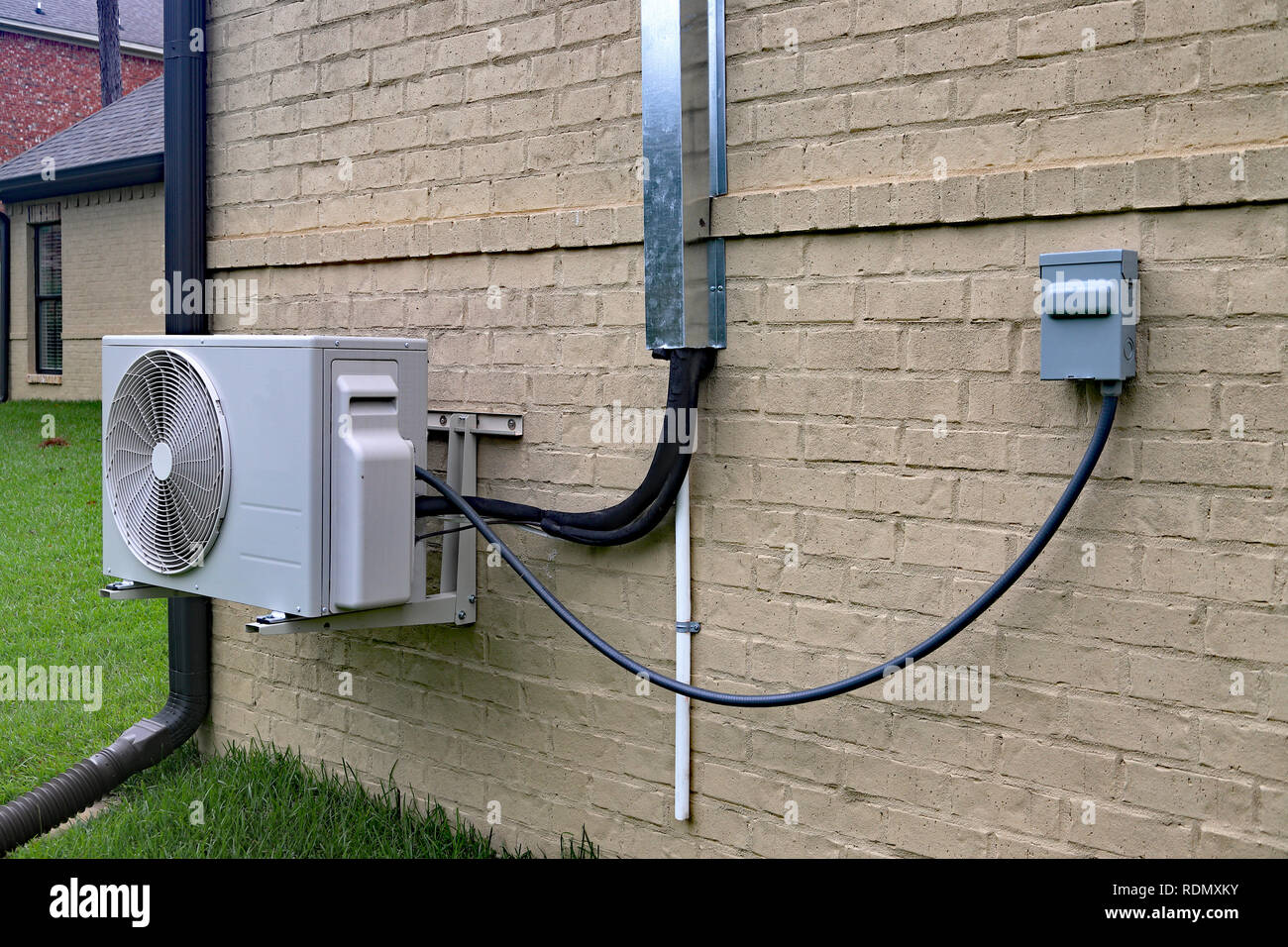 Sistema de aire acondicionado Mini Split junto a casa con pared de ladrillo  pintado y el espacio para la copia de texto Fotografía de stock - Alamy
