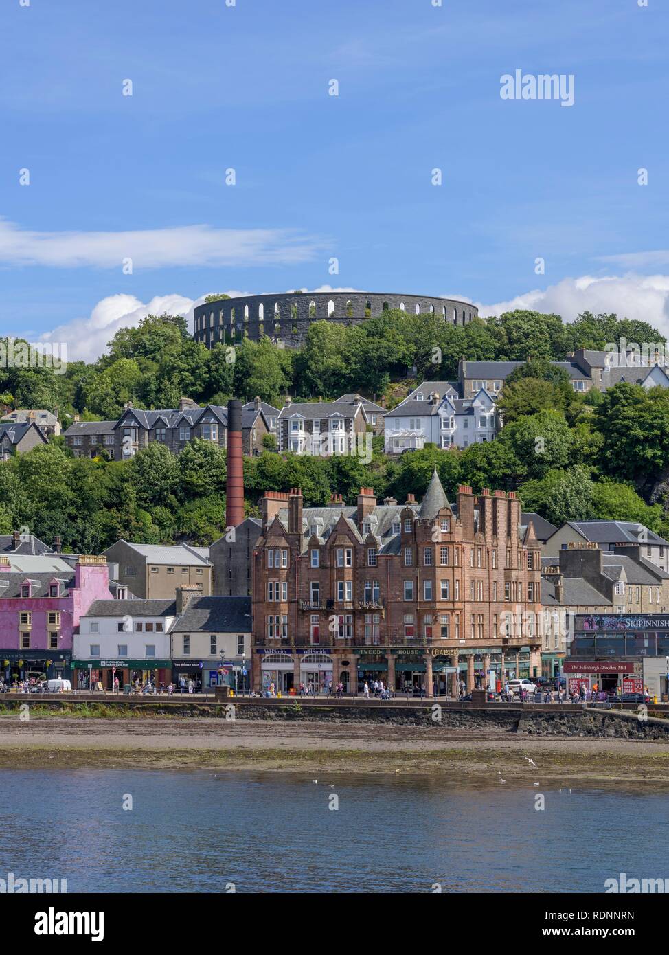 Vista desde el ferry a la aldea y la Torre de McCaig, Oban, Escocia, Reino Unido Foto de stock