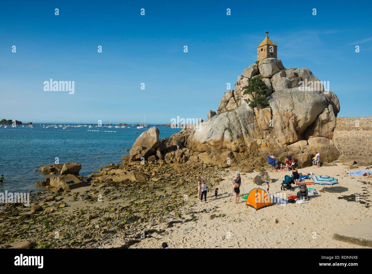 Playa y capilla sobre rocas, Port Blanc, Côte de Granit Rose, Cotes d'Armor, Bretaña, Francia Foto de stock