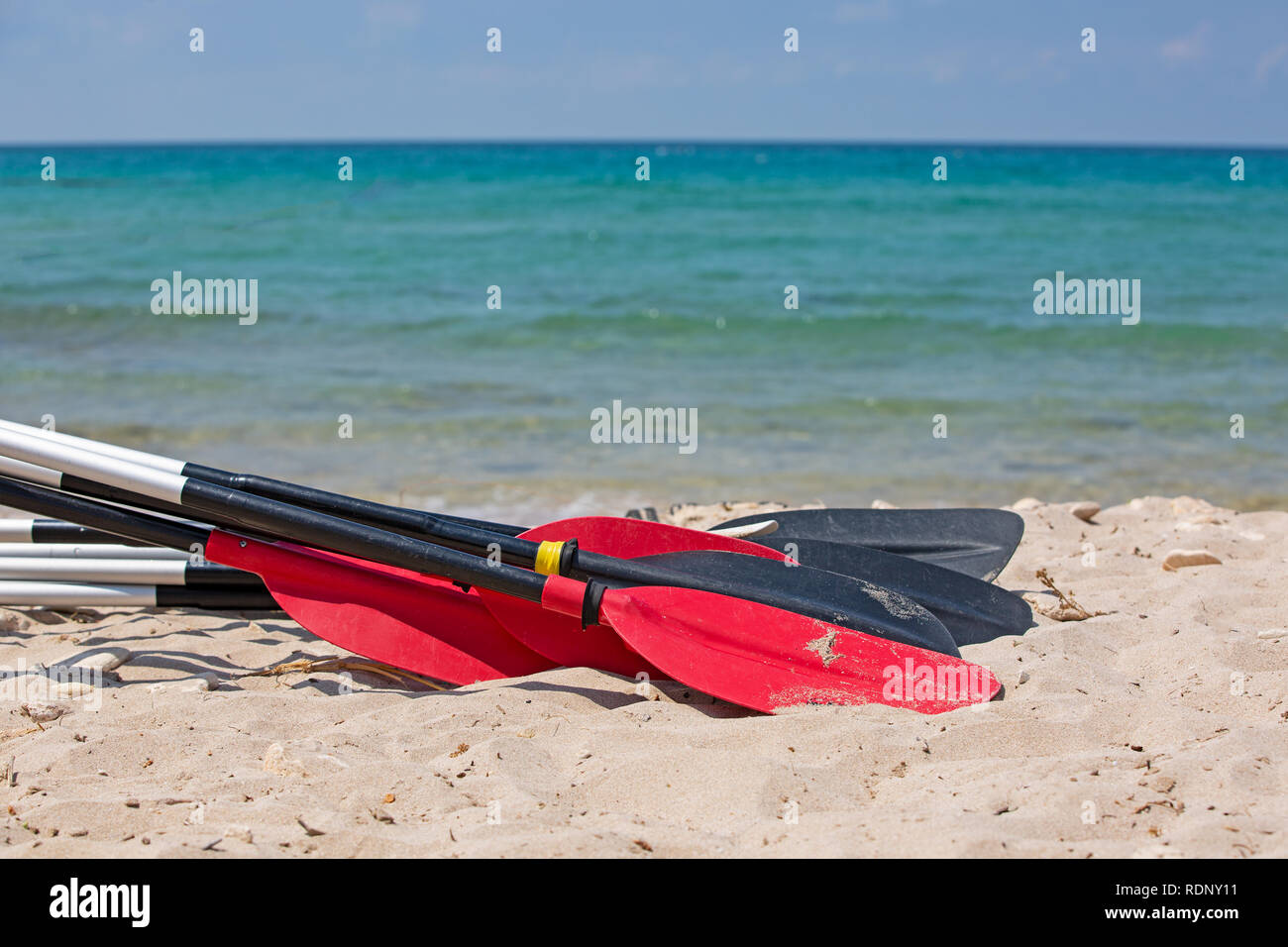 Bote remos tumbarse en la arena de la playa por el mar Foto de stock