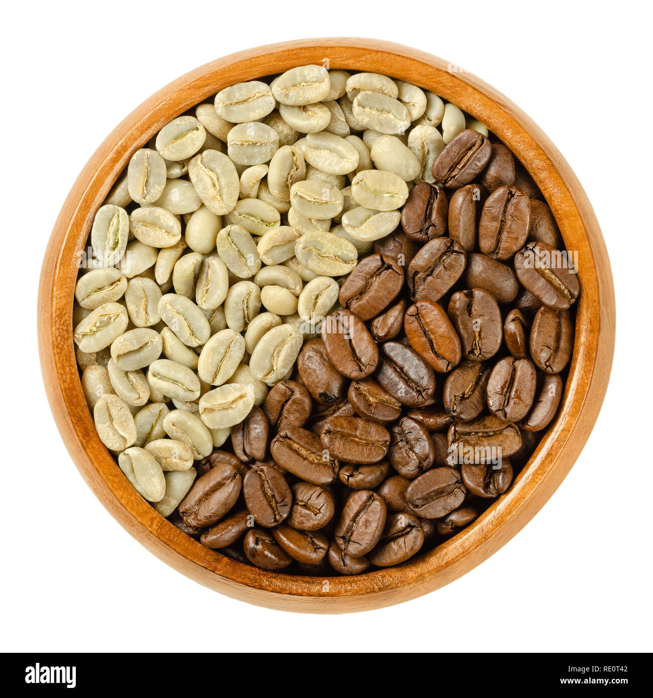 Verde y tostado de granos de café en Arabia tazón de madera. Las semillas de frutas de las cerezas de café o bayas. Punteaduras Unpulverized. Aisladas de alimentos macro fotografía. Foto de stock