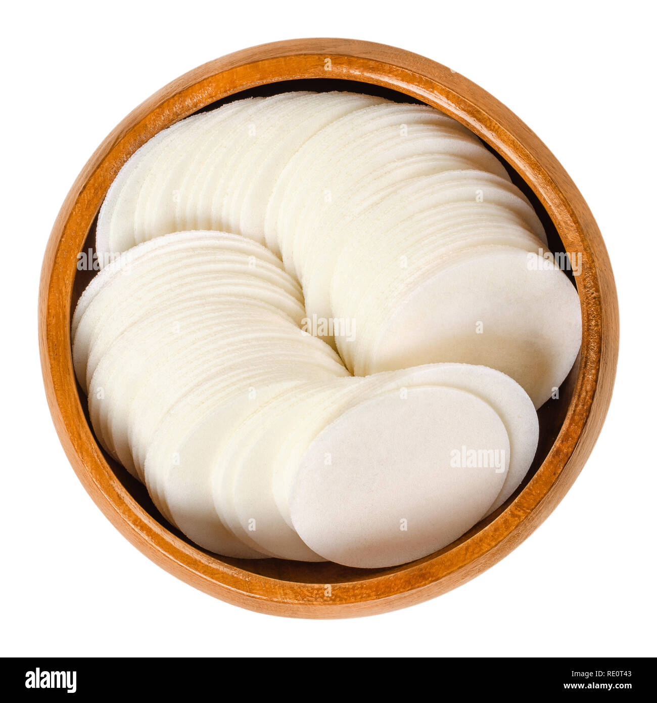 Oblea blanca redonda papeles para hornear en recipiente de madera. Láminas delgadas, hecha de harina de trigo y almidón, para hacer galletas. Comestible. Fotografía macro aisladas de alimentos Foto de stock