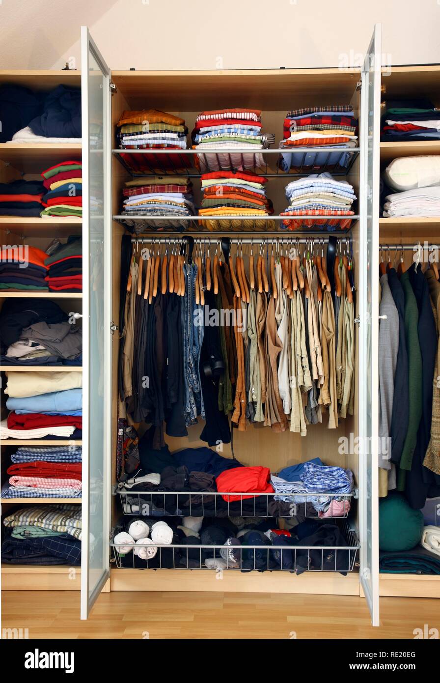 Un hombre del armario, ropa de todo tipo colgando o acostado en diferentes  compartimentos Fotografía de stock - Alamy