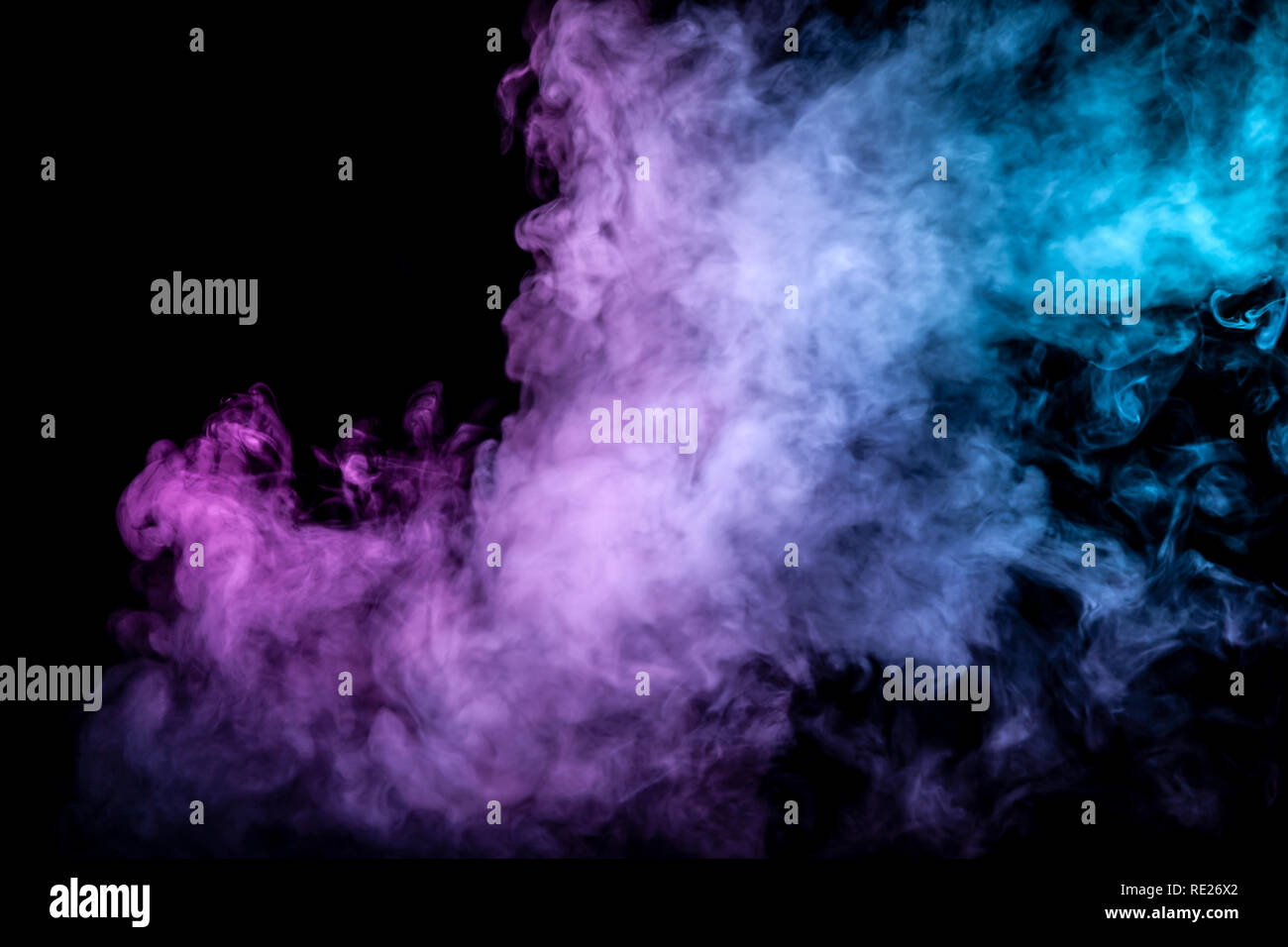 Nubes aisladas de humo de color: azul, rojo, verde, rosa; al desplazarse sobre un fondo negro en la oscuridad cerca. Foto de stock