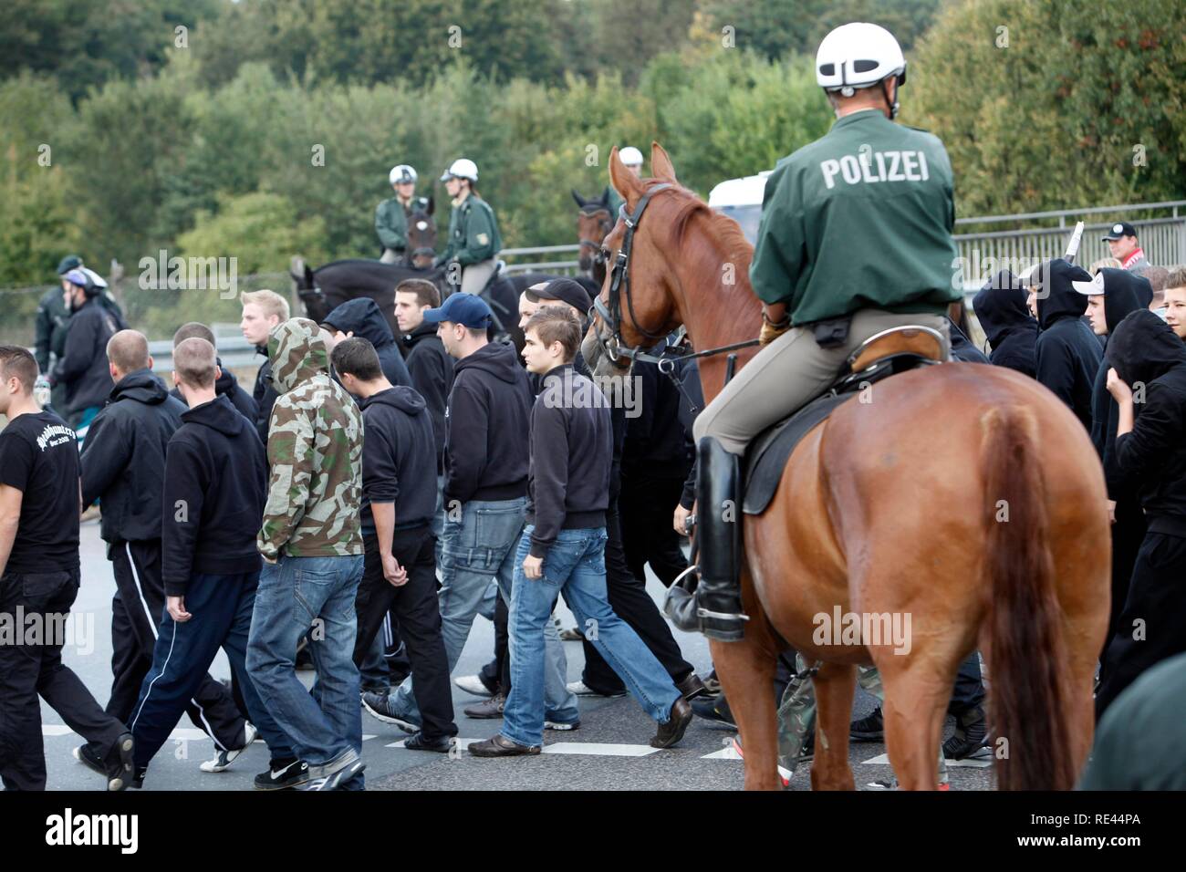 La policía montada en una operación policial en un partido de fútbol, acompañando a los fans del estadio Foto de stock