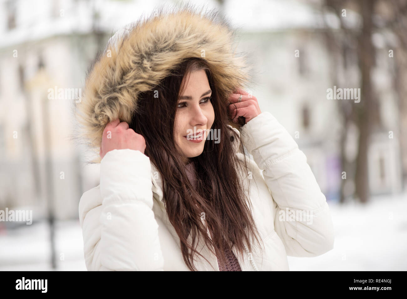 Hermosa joven en el medio del parque nevado. Cálido y confortable ropa de invierno, tiempo de invierno Foto de stock