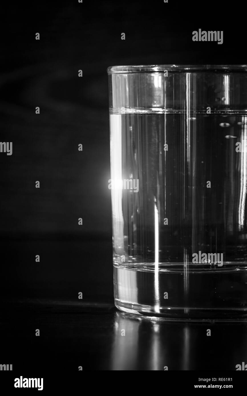 Un vaso de agua mineral pura está sobre la mesa. Foto de stock