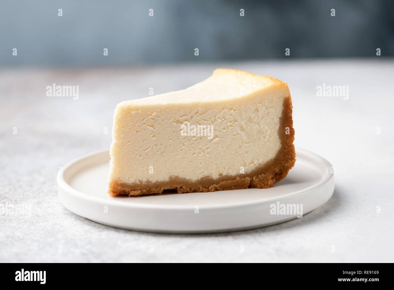 Rebanada de pastel de queso de Nueva York clásica en la placa blanca. Acercamiento Foto de stock