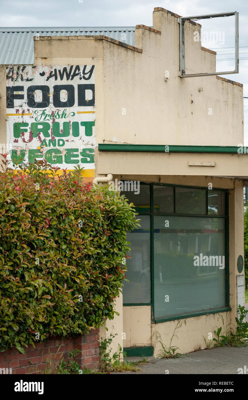 Un viejo y parcialmente pintado sobre Frutas y Hortalizas firmar al lado de una antigua tienda rural Victoria Australia Foto de stock