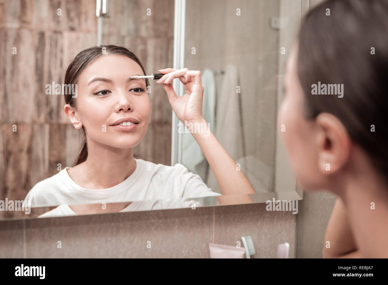 Mujer morena haciendo maquillaje en la mañana Fotografía de stock - Alamy