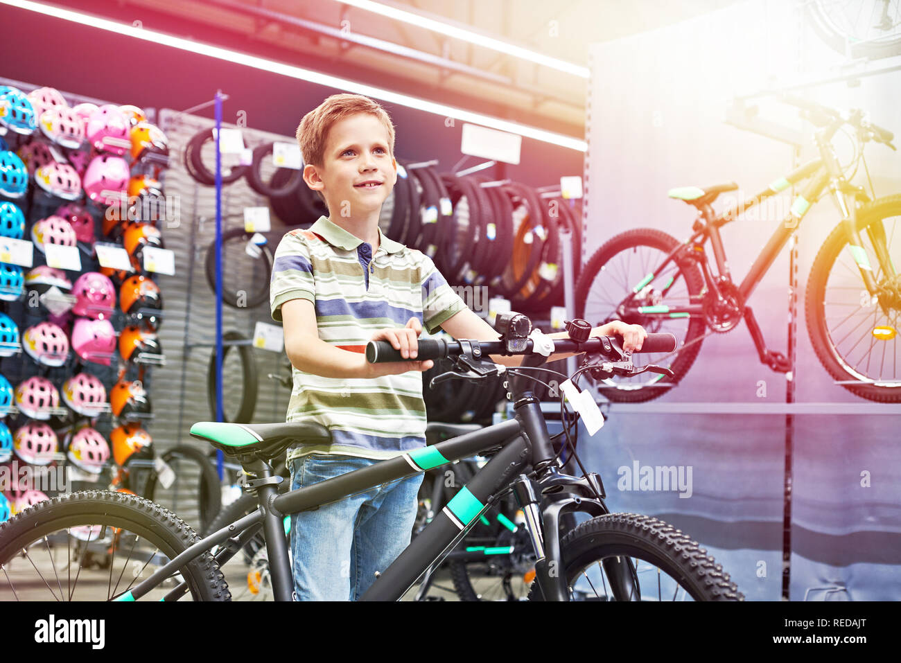 Chico y bicicleta en una tienda de deportes Foto de stock