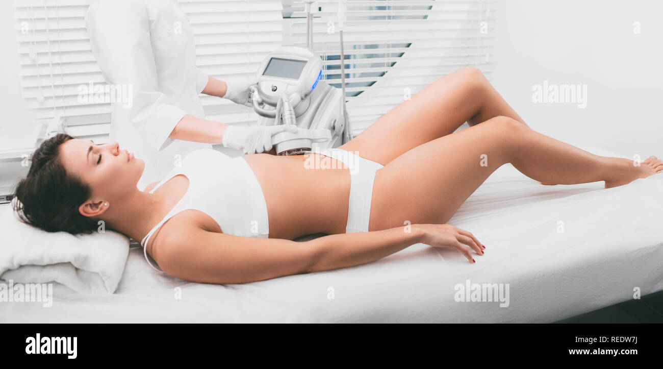 Hermosa mujer que la cavitación , tratamiento celulitis, sobre su abdomen en Beauty Clinic Foto de stock
