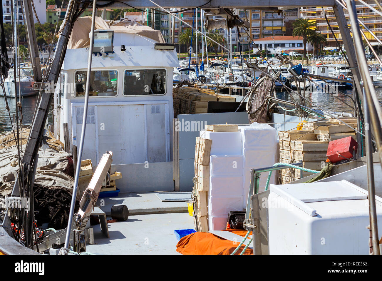 Los barcos de pesca y yates anclados en el muelle en el puerto de Blanes. Los pescadores descargan la captura de peces de mar, ostras, calamares, manjares de mar. Subasta de pescado para los mayoristas Foto de stock