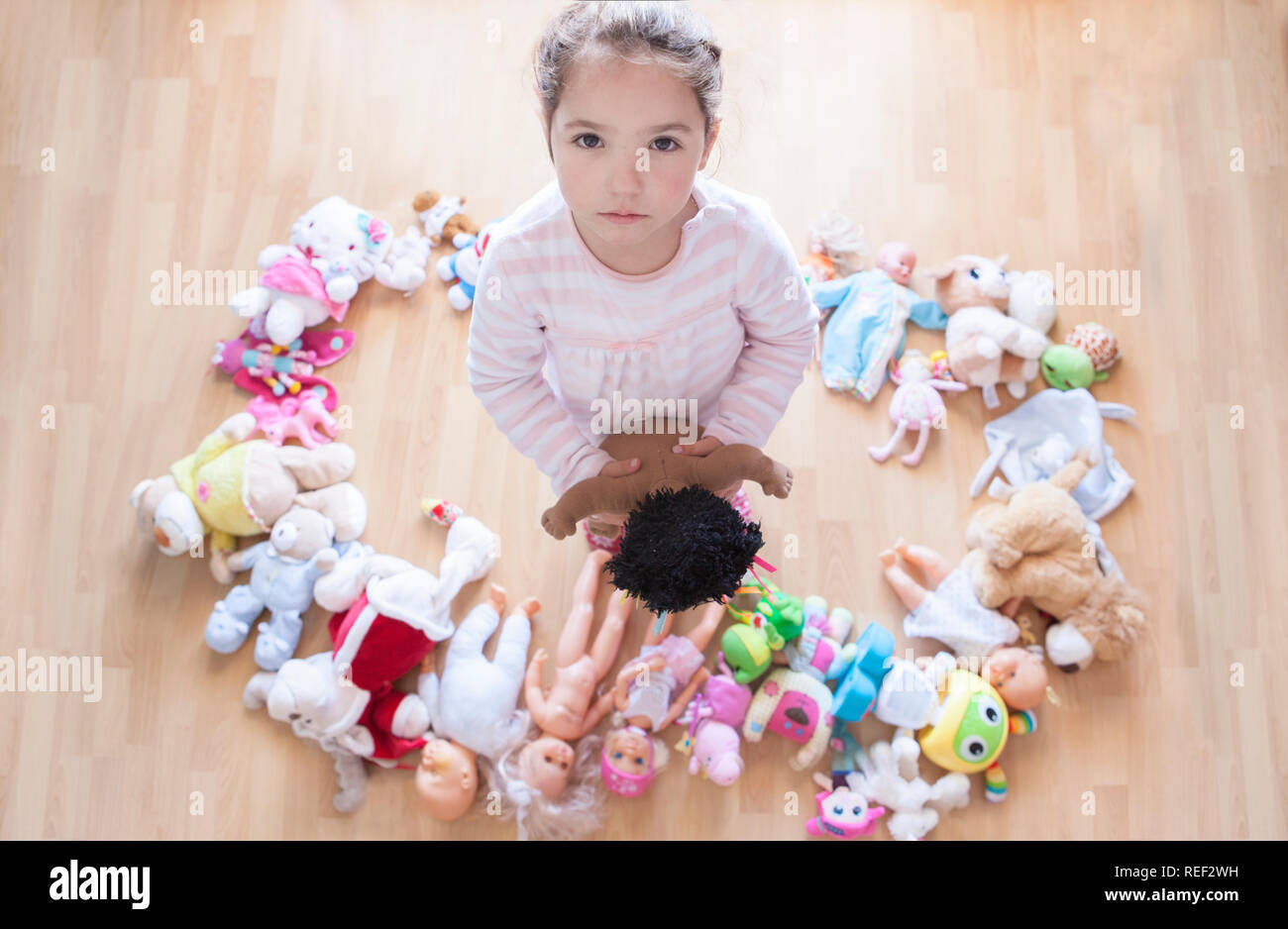Niña de 5 años descontentos con un montón de juguetes. Demasiados juguetes  en concepto de comportamiento y desarrollo infantil. Vista aérea Fotografía  de stock - Alamy