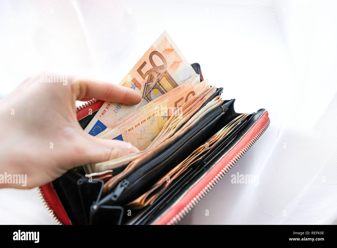 Mujer sosteniendo billetera llena de billetes de euro dinero y billetes.  Concepto de robar dinero, gente rica, de ahorros o de gastar dinero.  Contando el pago Fotografía de stock - Alamy