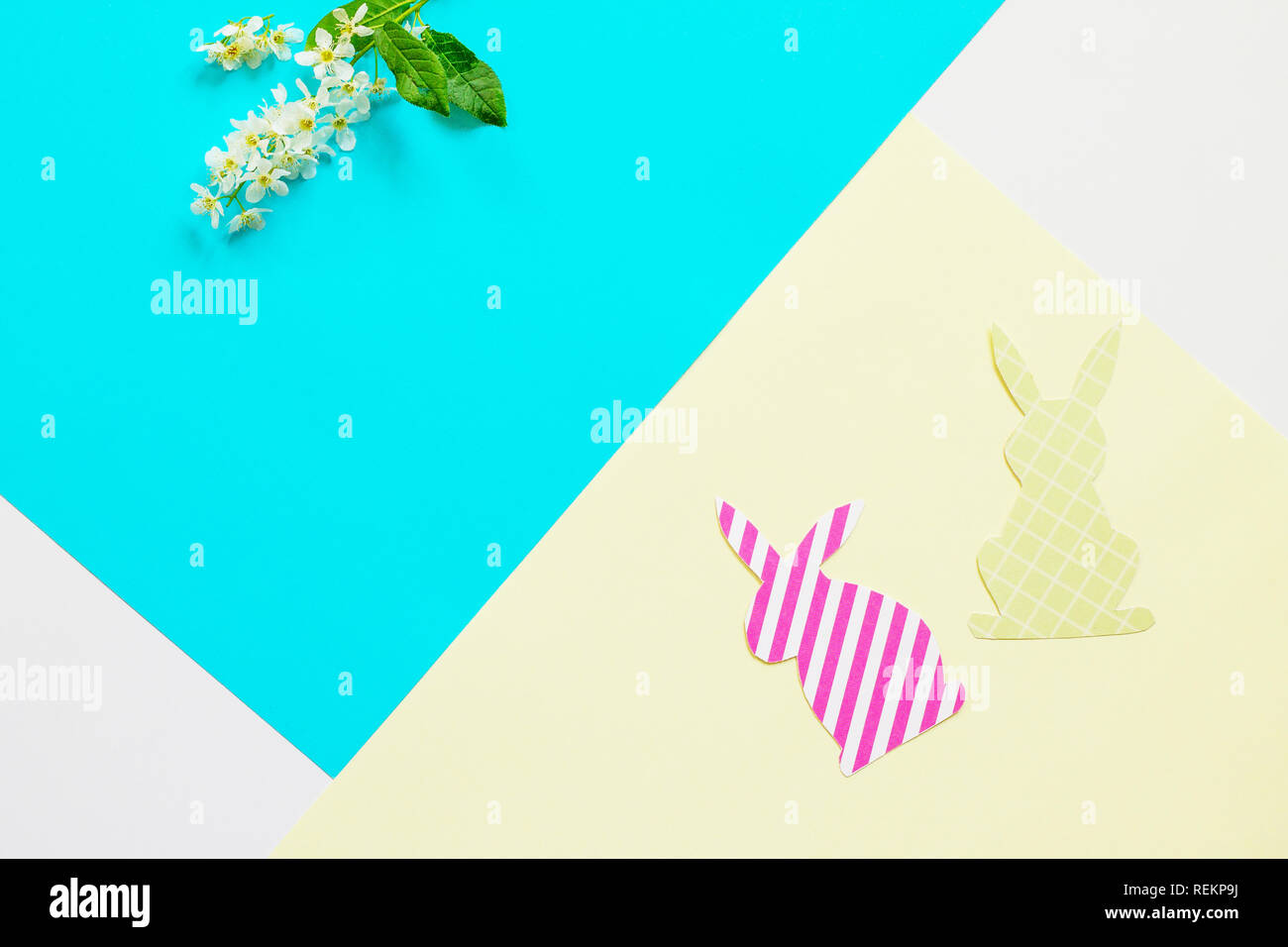Conejito de Pascua de papel y las flores de la primavera. Mínimo concepto de pascua. Vista superior de la lay de fondo plano. Copie el espacio. Foto de stock