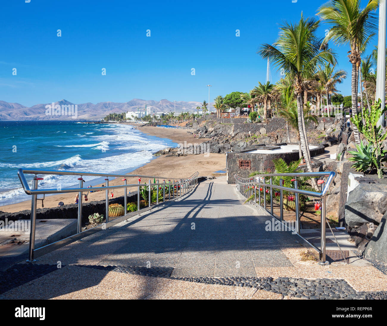 La playa de Puerto del Carmen en Lanzarote, Islas Canarias, España. mar  azul, palmeras, el enfoque selectivo Fotografía de stock - Alamy