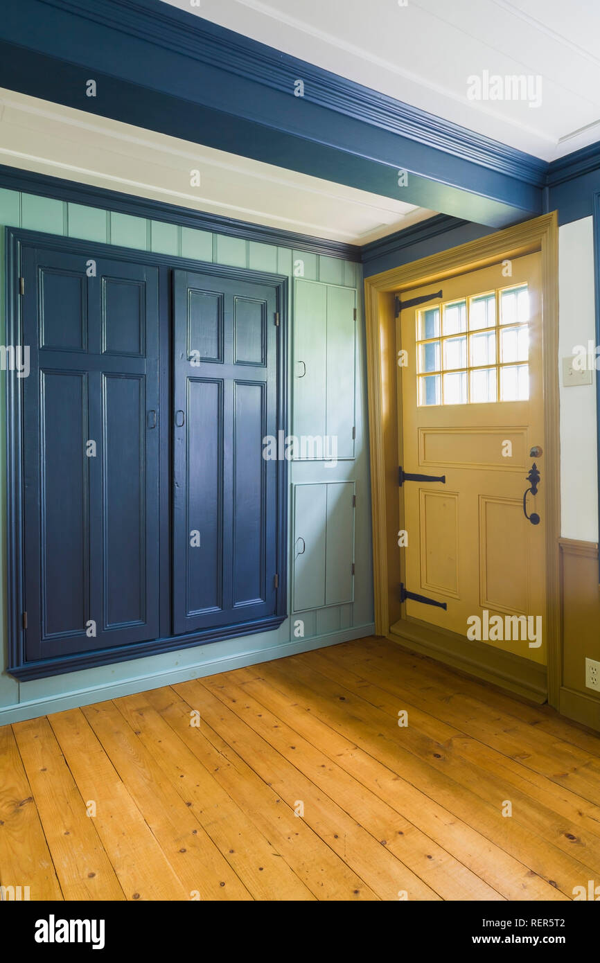 De madera pintados de amarillo puerta trasera con cristal ventana, armarios  con puertas azules en salon comedor con suelos de madera dentro de una  vieja casa de 1809 Fotografía de stock - Alamy