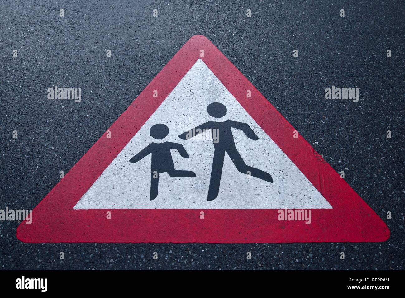 Señales de tráfico atención a niños jugando en la calle mojada con lluvia, Baviera, Alemania Foto de stock