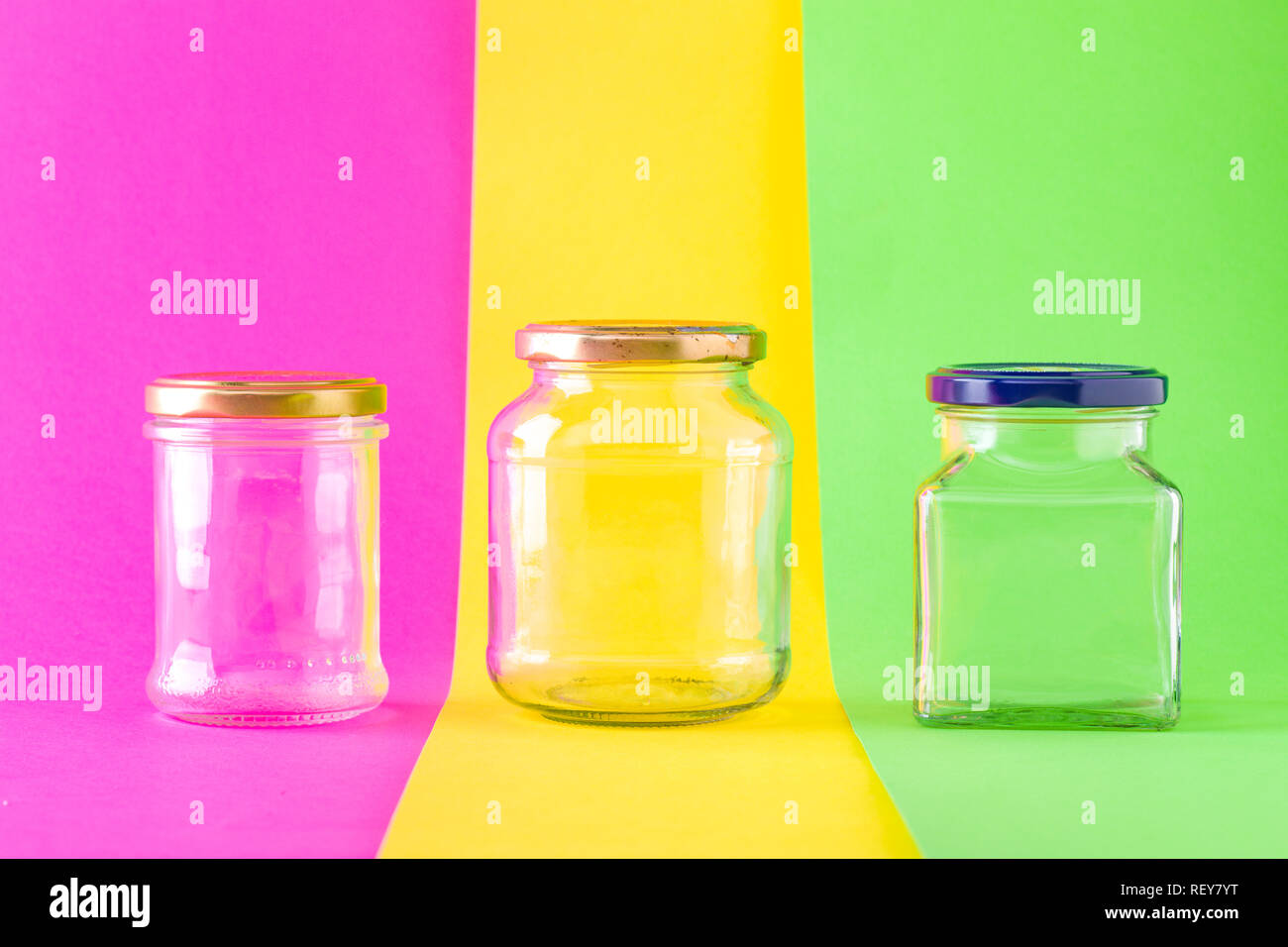Tres frascos de vidrio vacíos sobre fondo multicolor Foto de stock