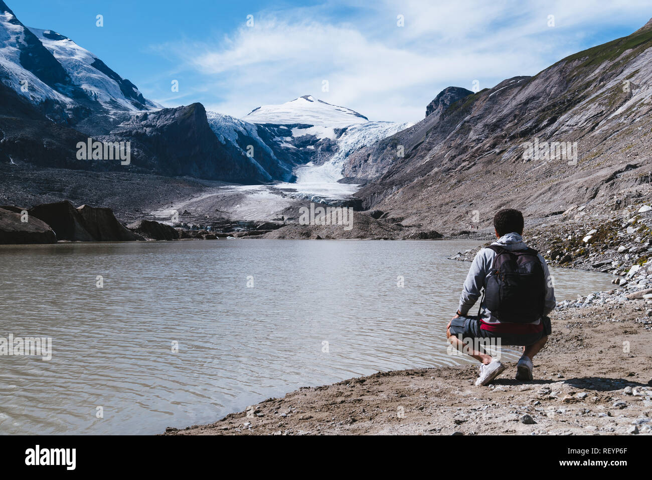 Hombre mirando al lago glaciar alpino un día soleado de verano. El glaciar Grossglockner en Austria. Concepto de estilo de vida y aventura Foto de stock