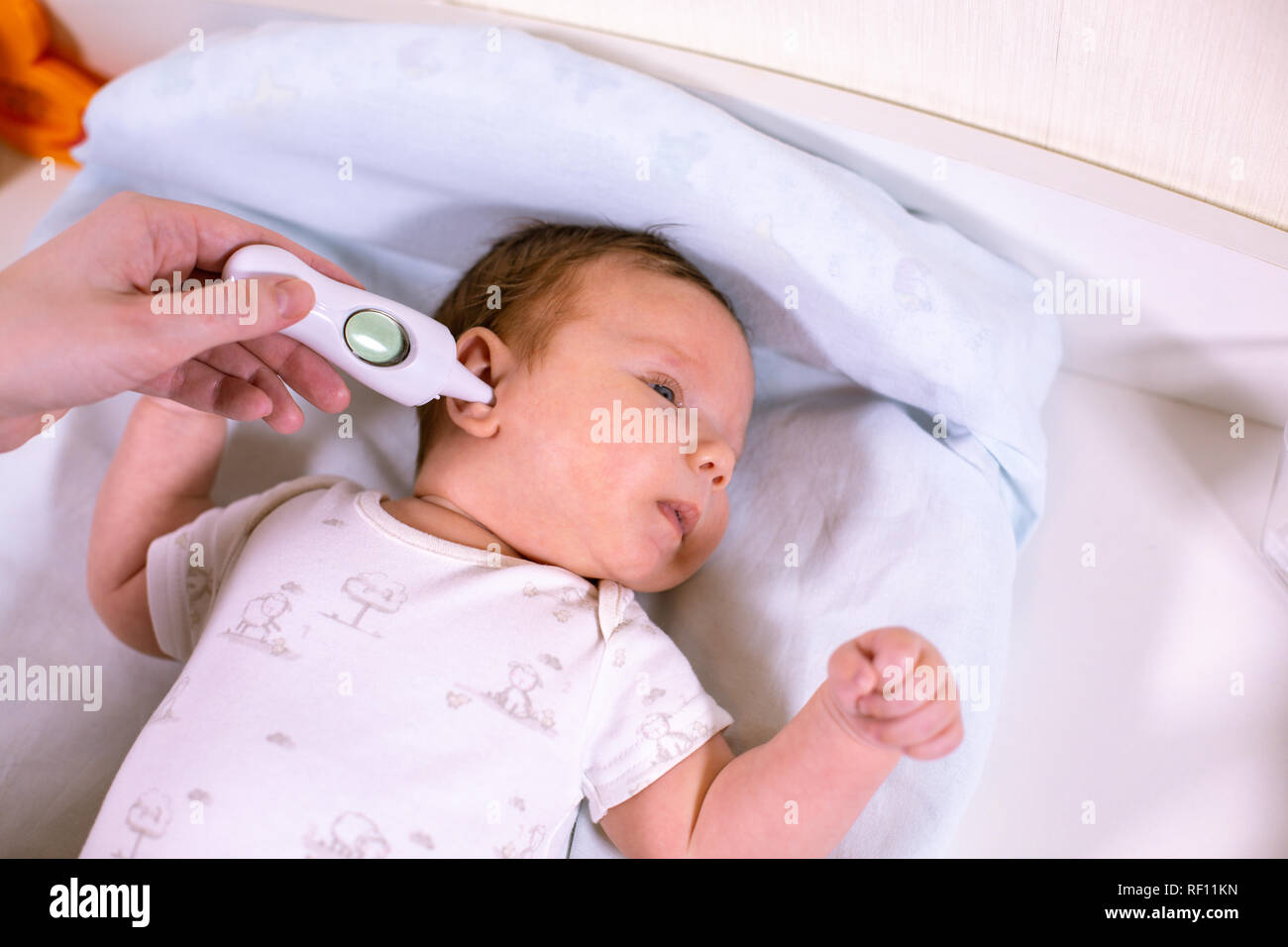 Medir la temperatura del bebé con termómetro sin contacto. Mamá mide la  temperatura corporal del bebé con un termómetro en el oído Fotografía de  stock - Alamy