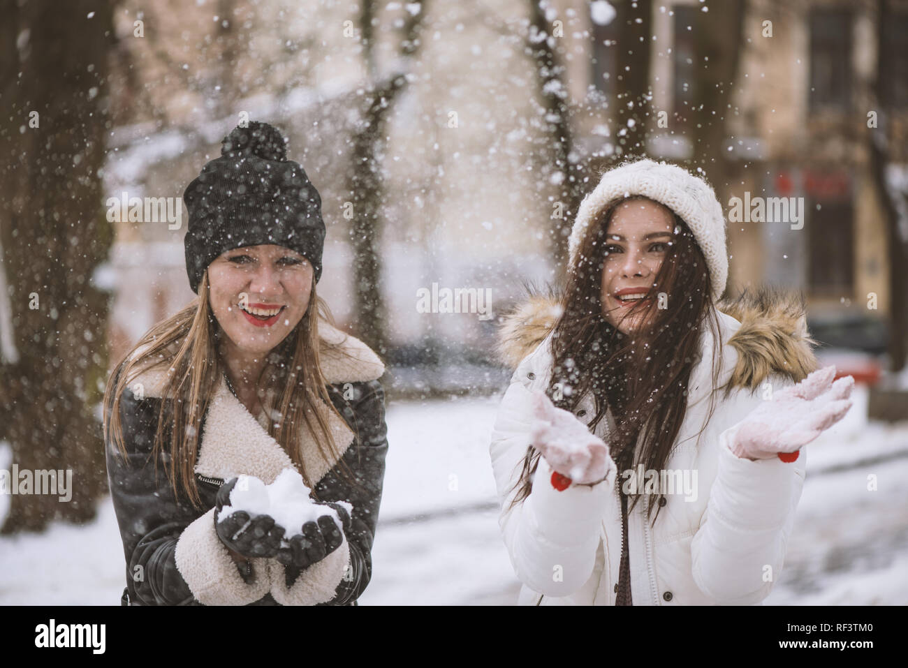 Niña jugando con nieve niña en guantes mantenga bola de nieve invierno  mujer sonriente en ropa de abrigo con