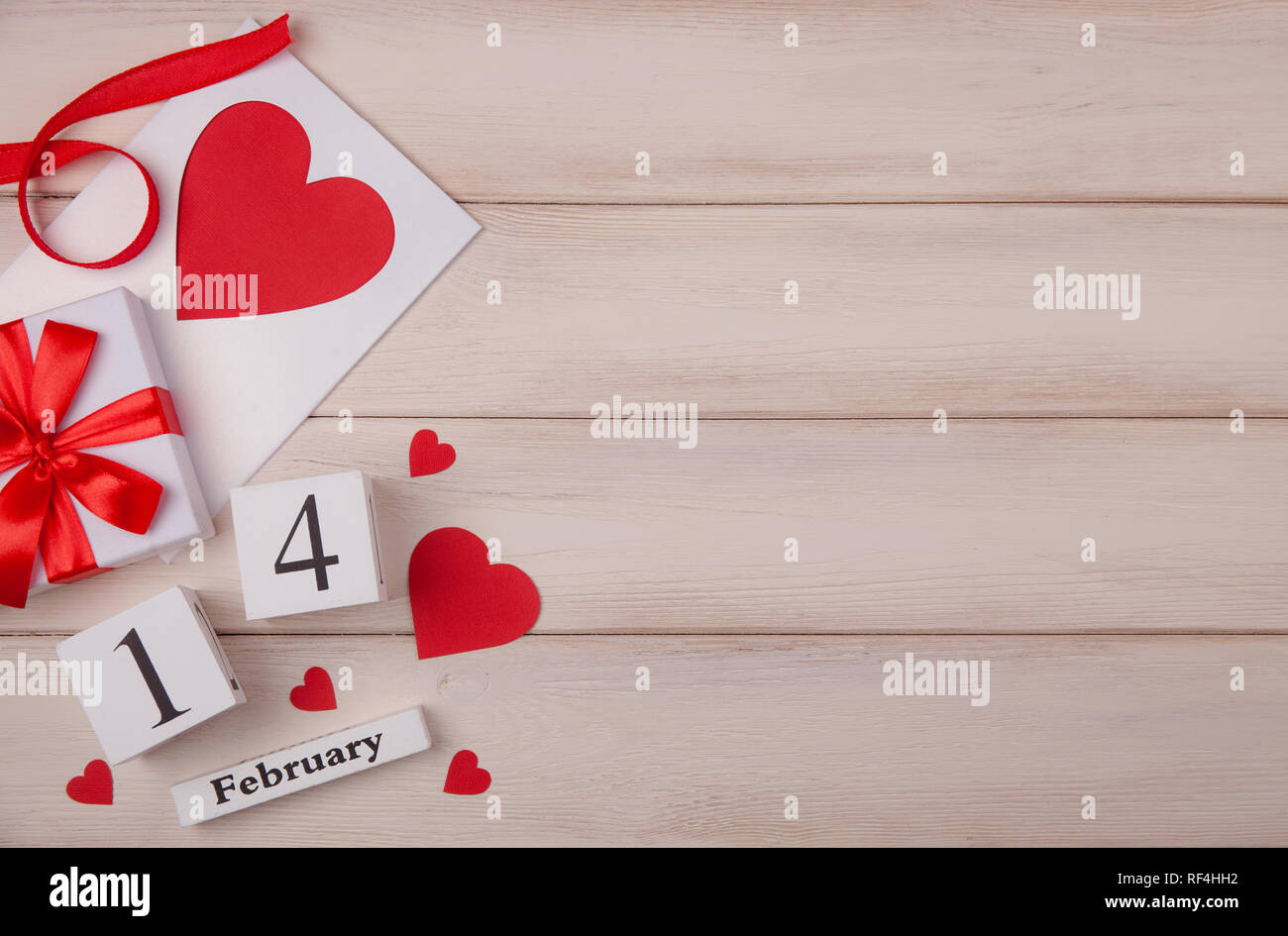 Fondo blanco de madera con corazones rojos, regalos, amor y un bloque de madera sobre el calendario. El concepto de Día de San Valentín. Vista superior. Copie el espacio para el texto. Foto de stock