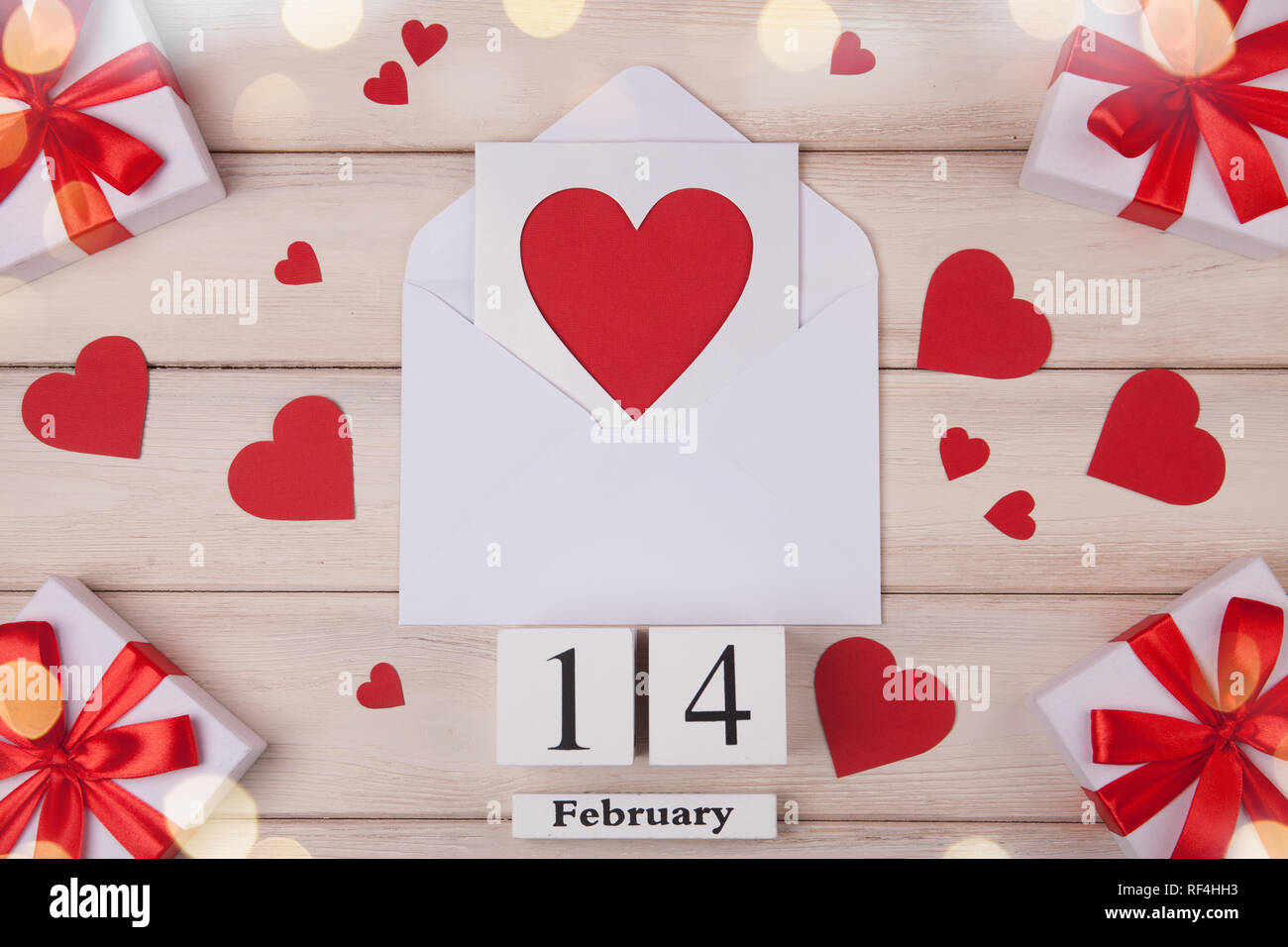 Fondo blanco de madera con corazones rojos, regalos, amor y un bloque de madera sobre el calendario. El concepto de Día de San Valentín. Vista superior. Foto de stock